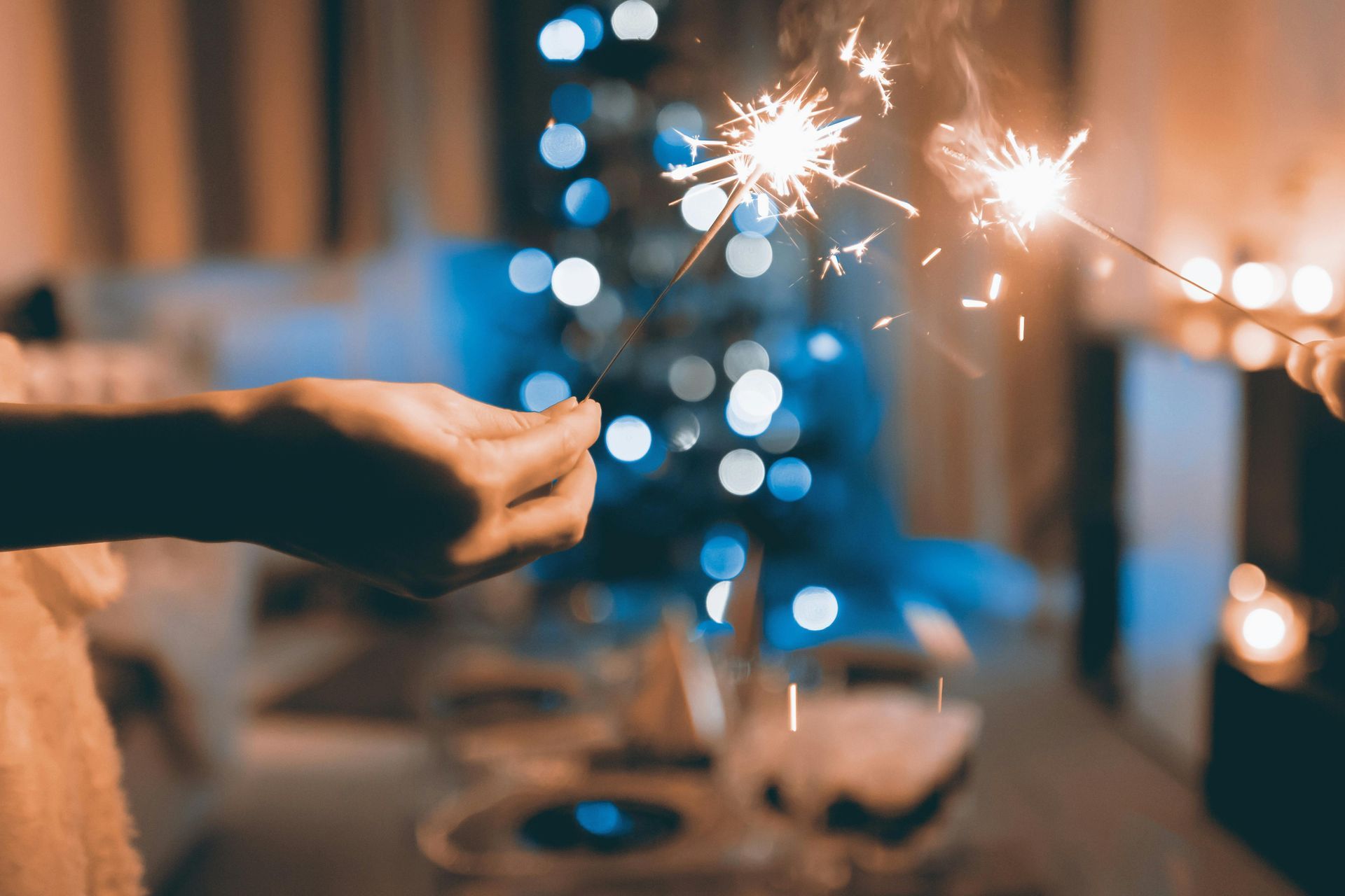 Two people are holding sparklers in their hands in front of a christmas tree. Divorce. Separation.