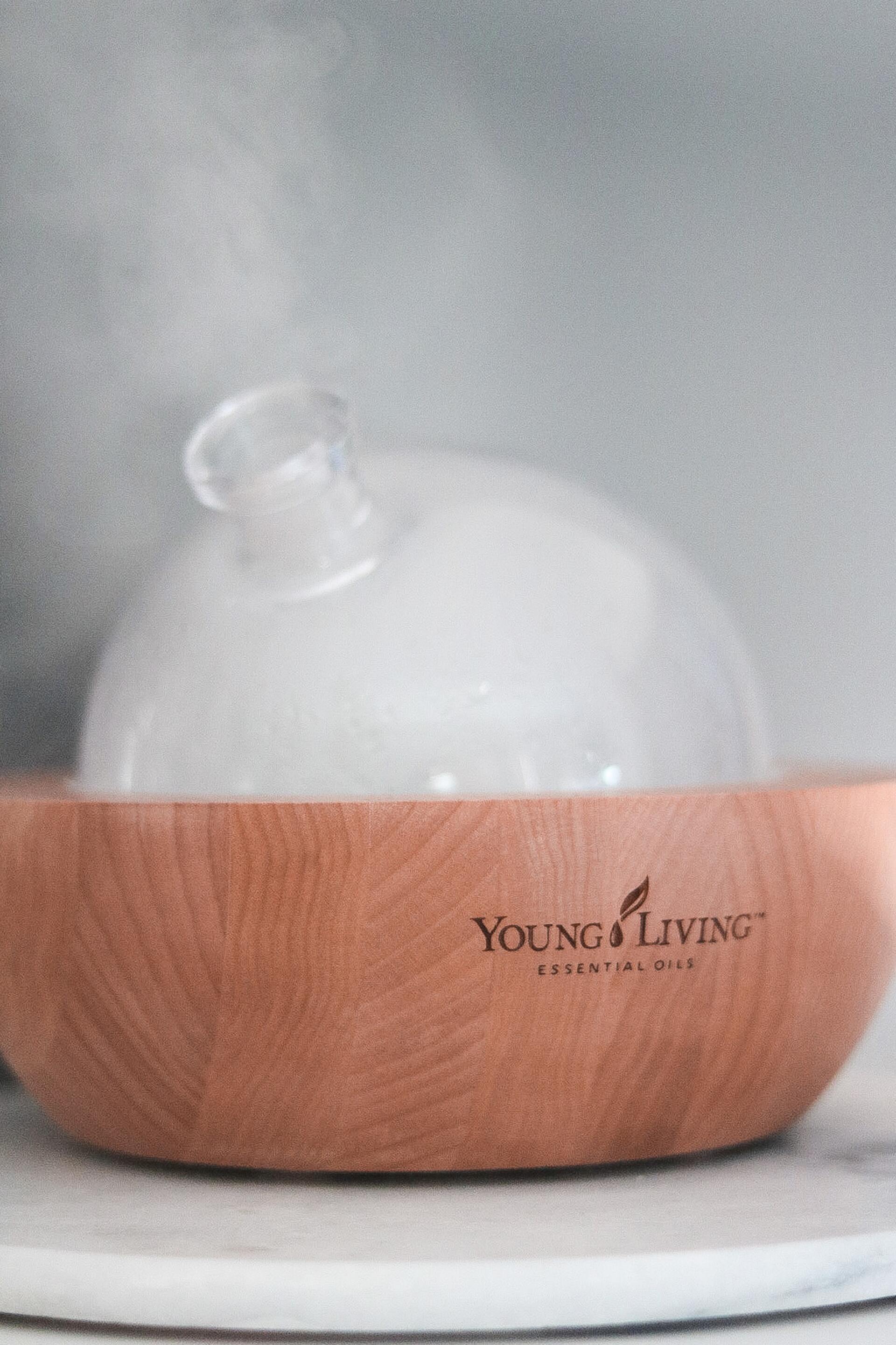aria young living diffuser brown base and glass top diffusing oils. Young Living logo on base