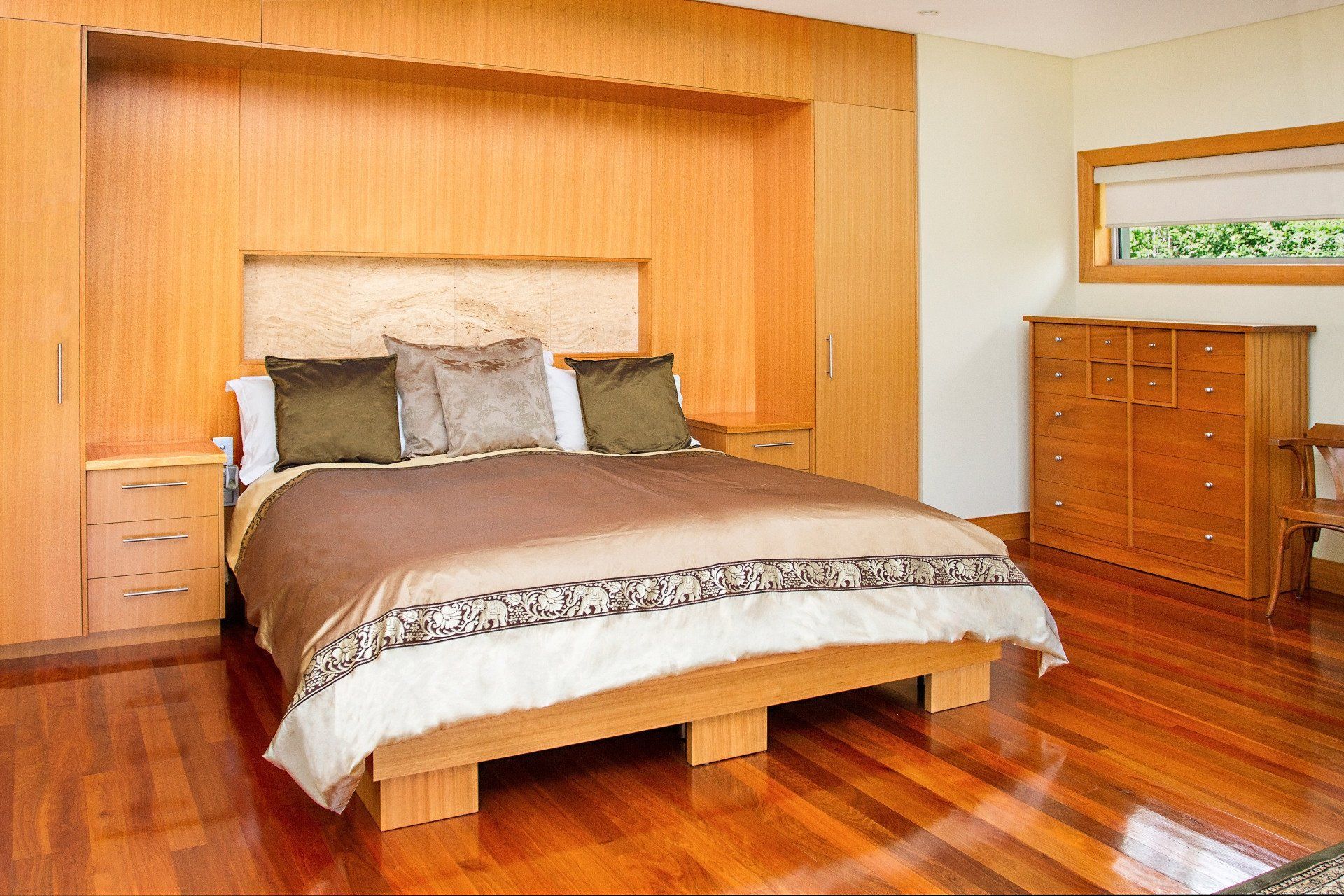 A Bedroom with Hardwood Floors and A Large Bed — Marlix Custom Timber Furniture Design and Joinery in Unanderra, NSW