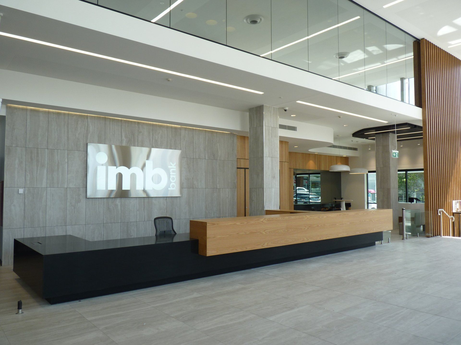 A Large Lobby with A Long Desk and A Sign that Says ' Imbi ' on The Wall — Marlix Custom Timber Furniture Design and Joinery in Unanderra, NSW