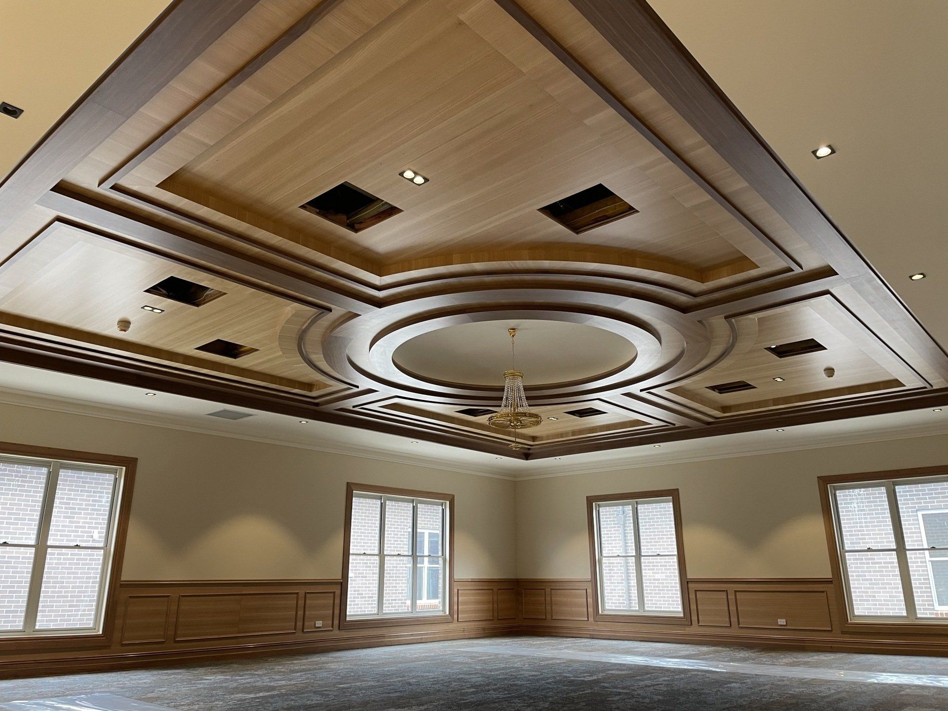 An Empty Room with A Wooden Ceiling and A Chandelier — Marlix Custom Timber Furniture Design and Joinery in Unanderra, NSW