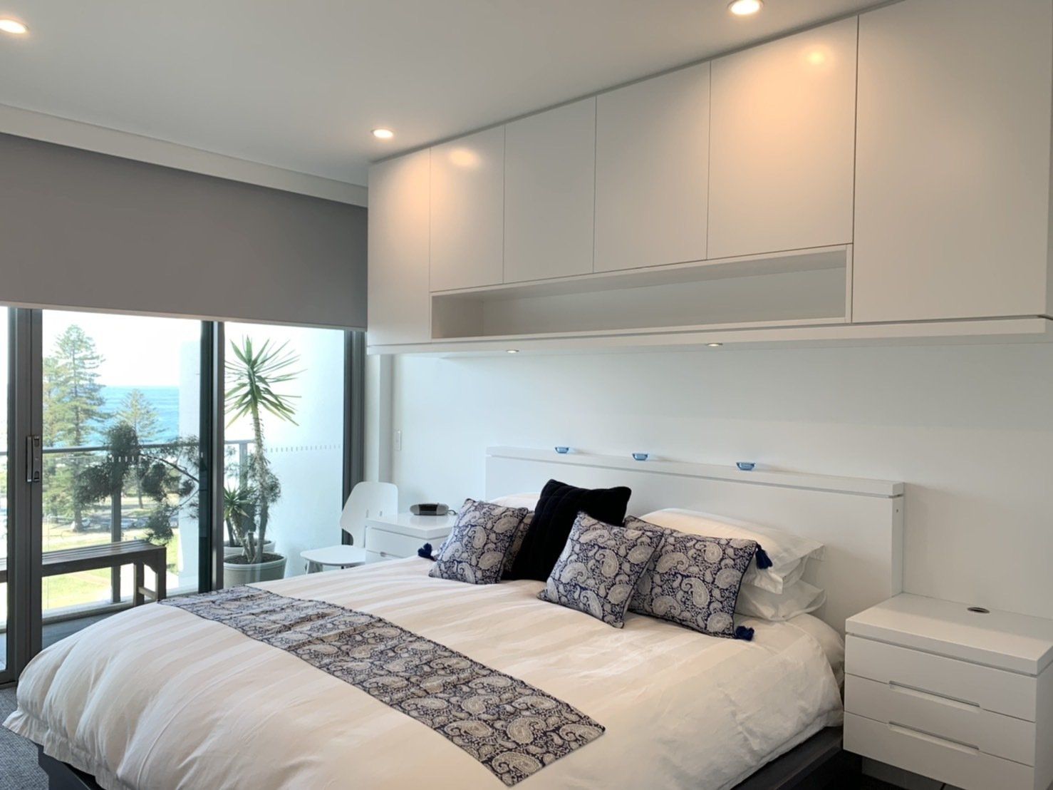 A Bedroom with A Large Bed, Nightstands, and A Balcony — Marlix Custom Timber Furniture Design and Joinery in Unanderra, NSW