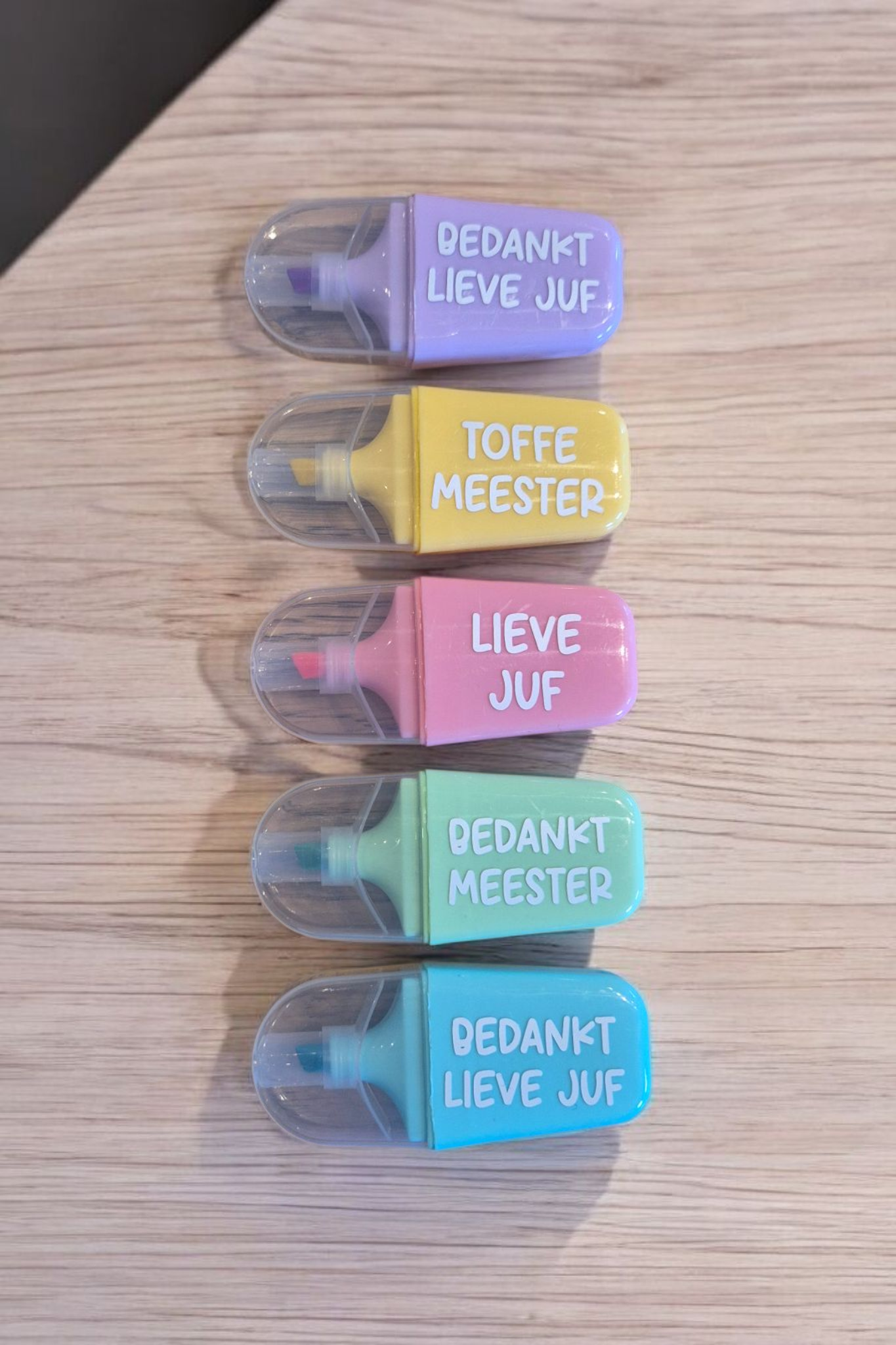 Five colorful highlighters with Dutch phrases: