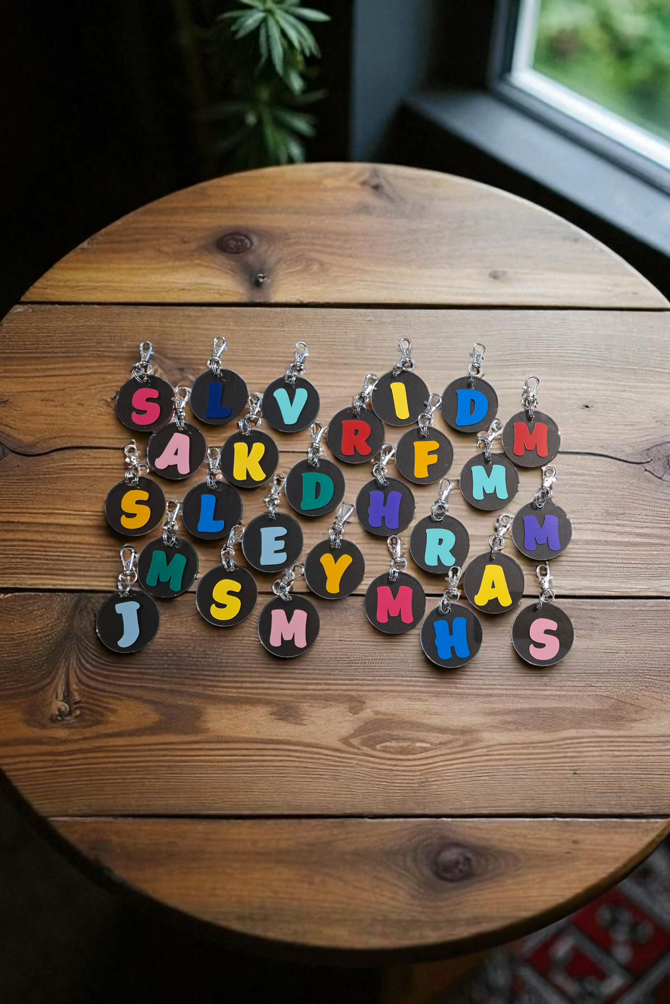 Ronde houten tafel met kleurrijke sleutelhangers in de vorm van letters.