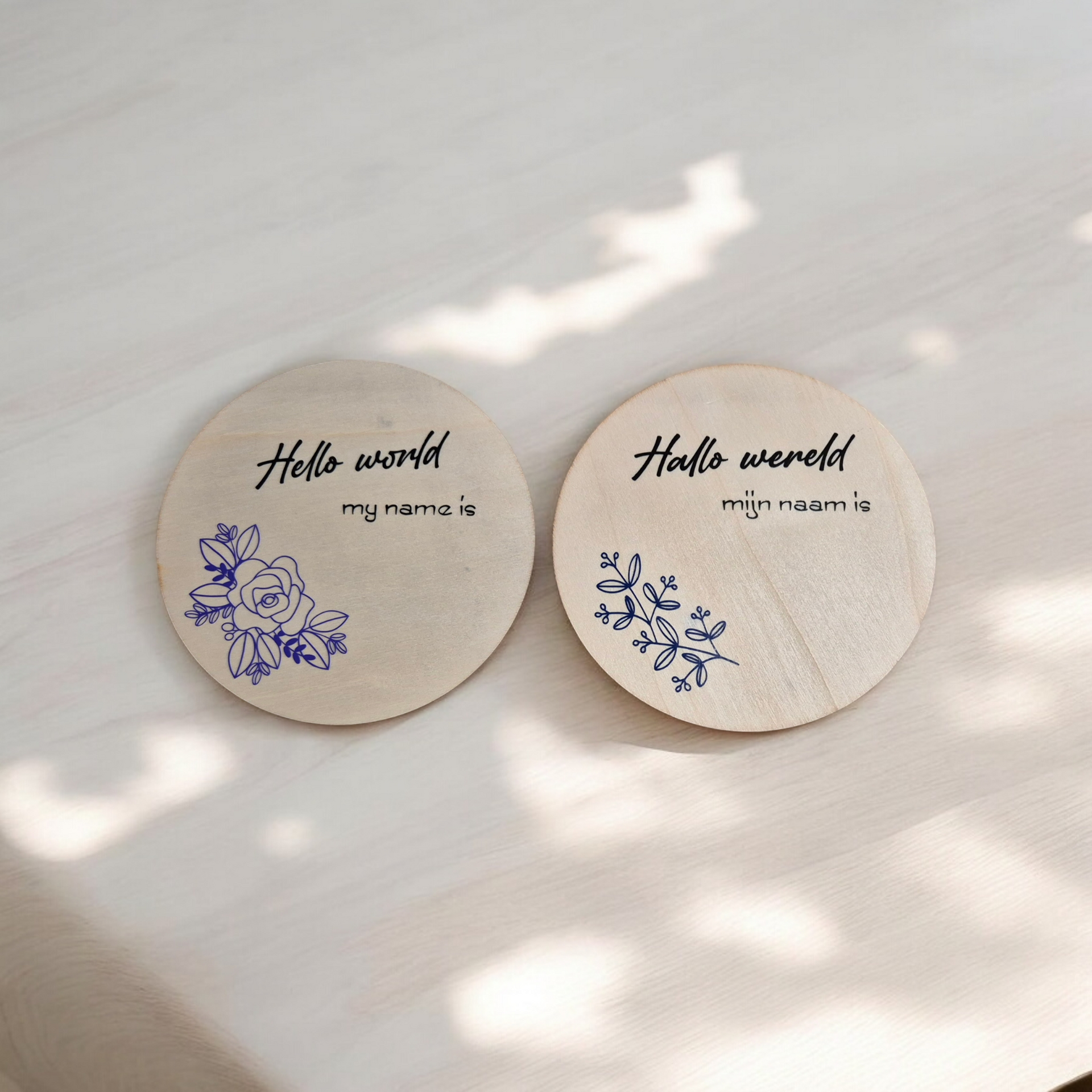 Two wooden discs with blue floral designs and text: