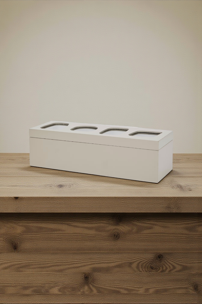 Een witte doos met vier ronde openingen staat op een houten ondergrond.
