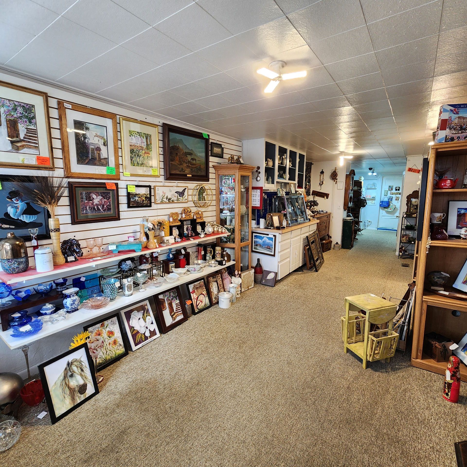 A room with a lot of pictures on the wall and shelves