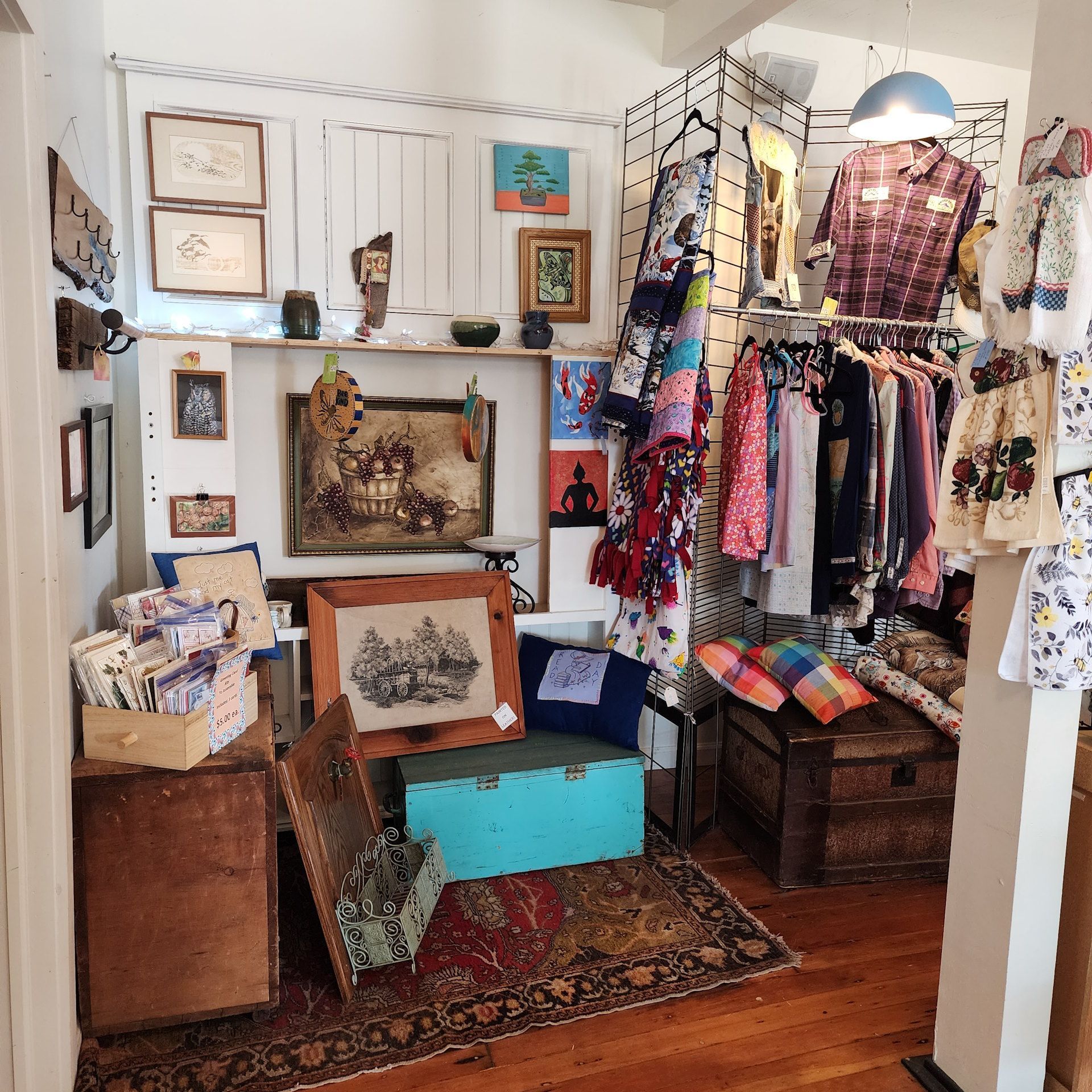 A room filled with lots of clothes and paintings