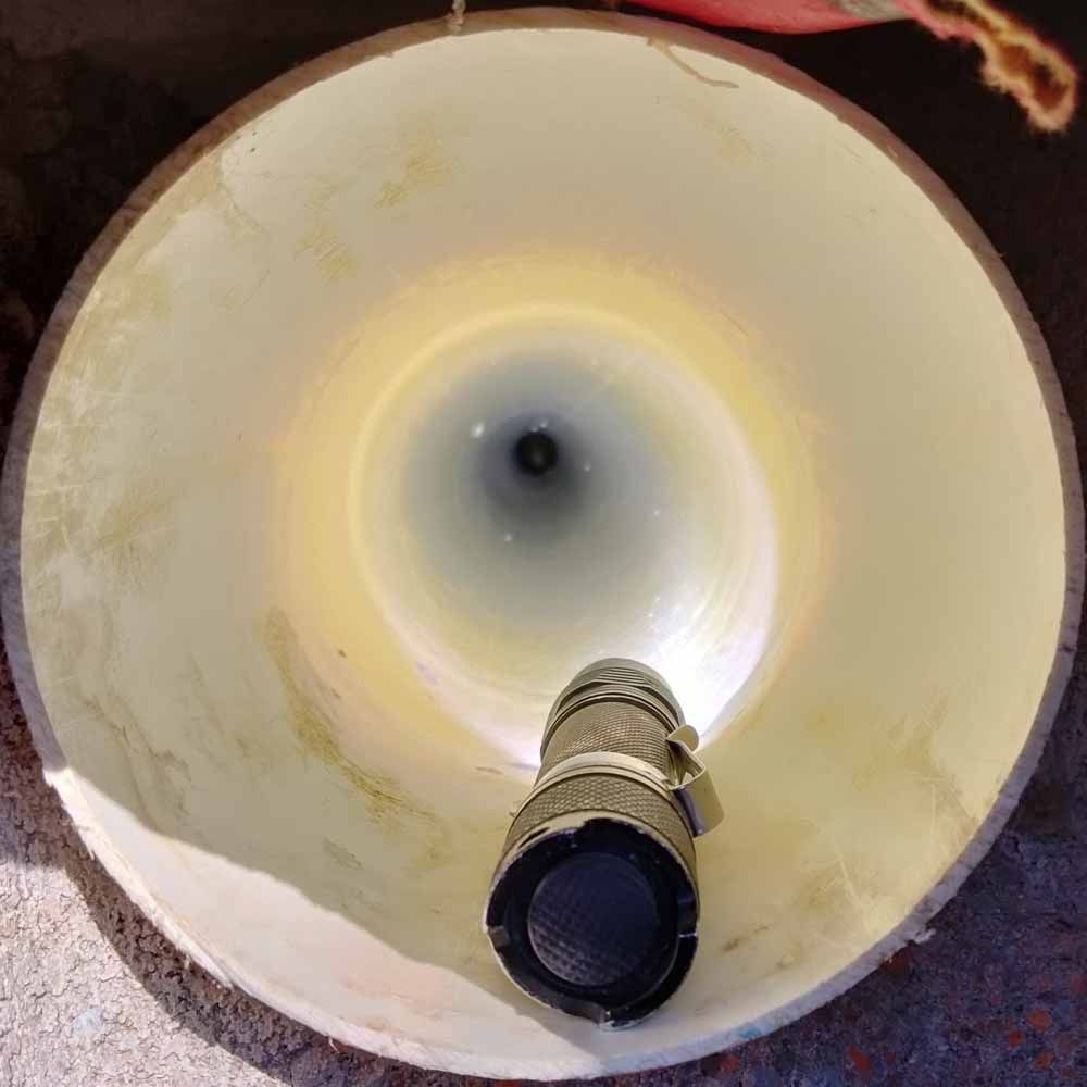 Close-up of a large cream-colored megaphone with a black mouthpiece, viewed from the bell end.