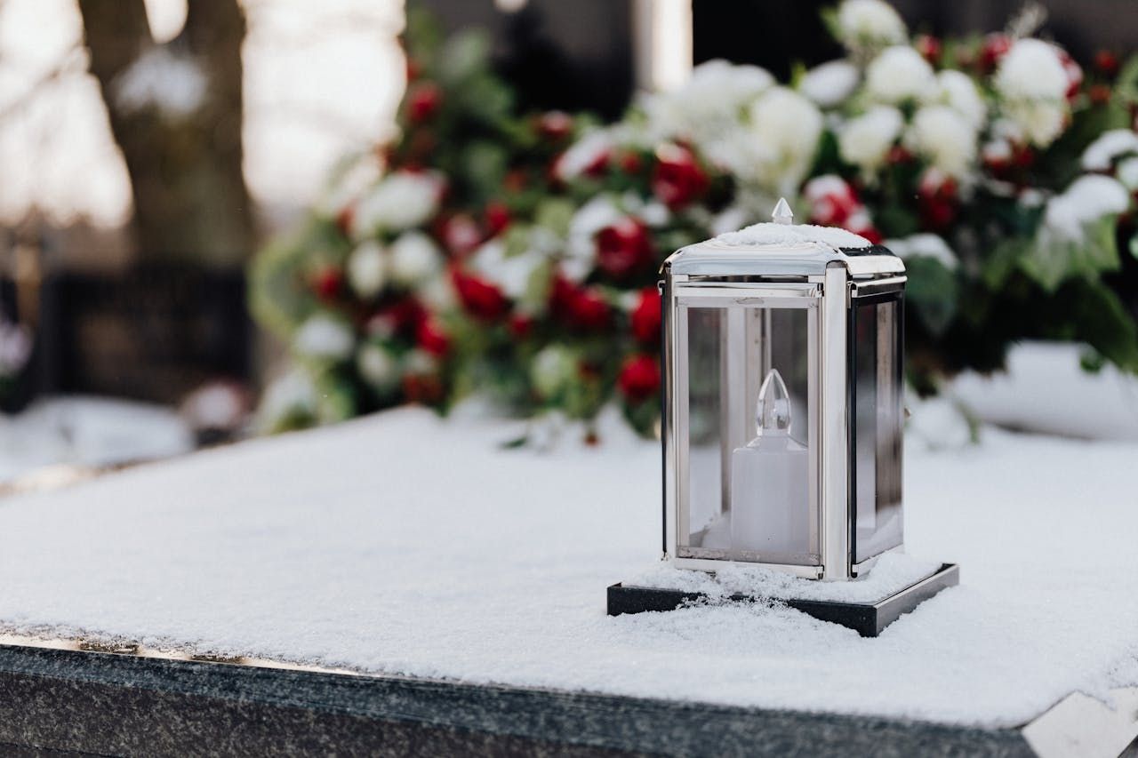 Lamp in snow  in a  cemetery 