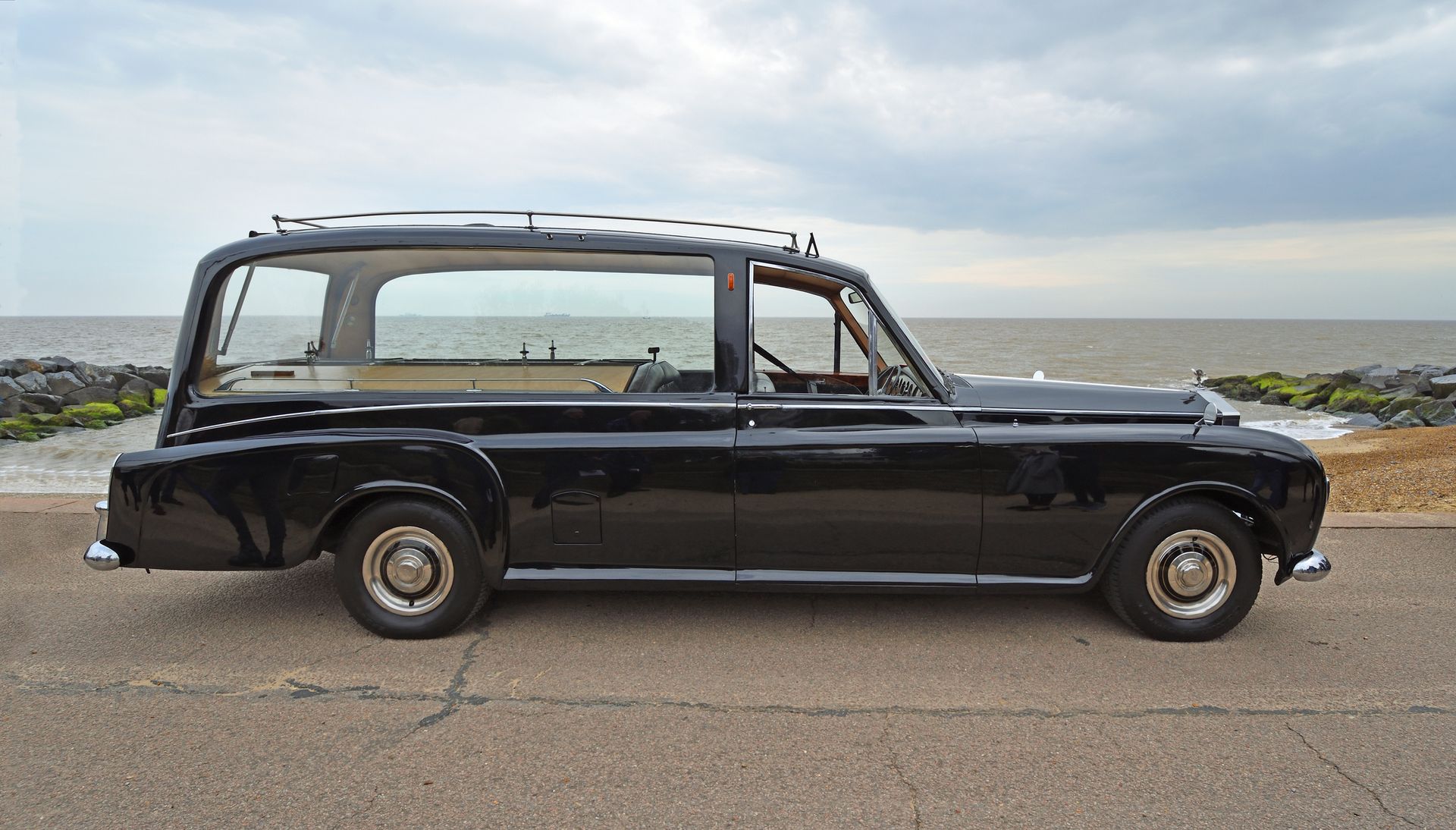 Funeral hearse in front of a coastal background