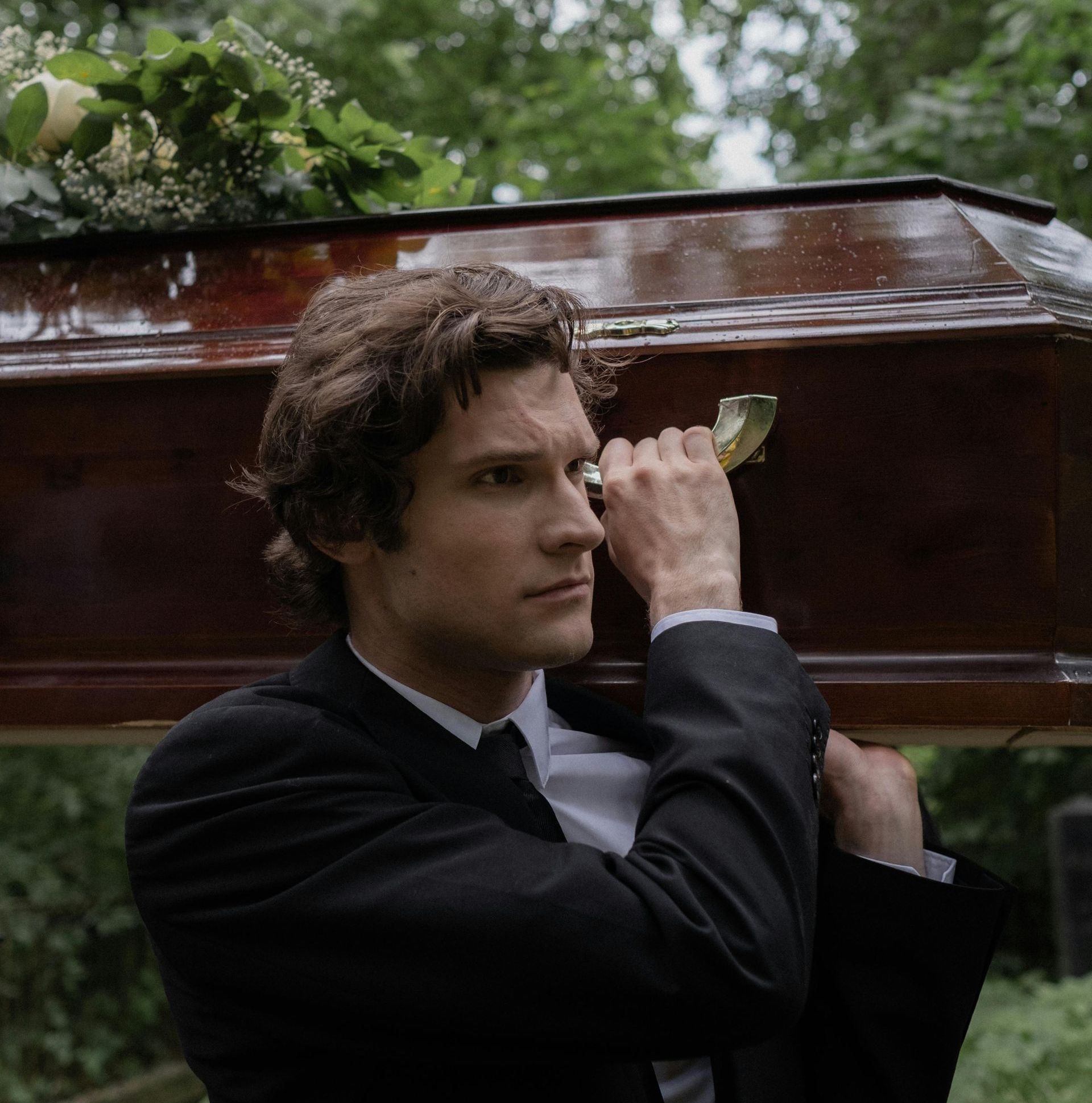 Pallbearer carrying a coffin on his shoulder