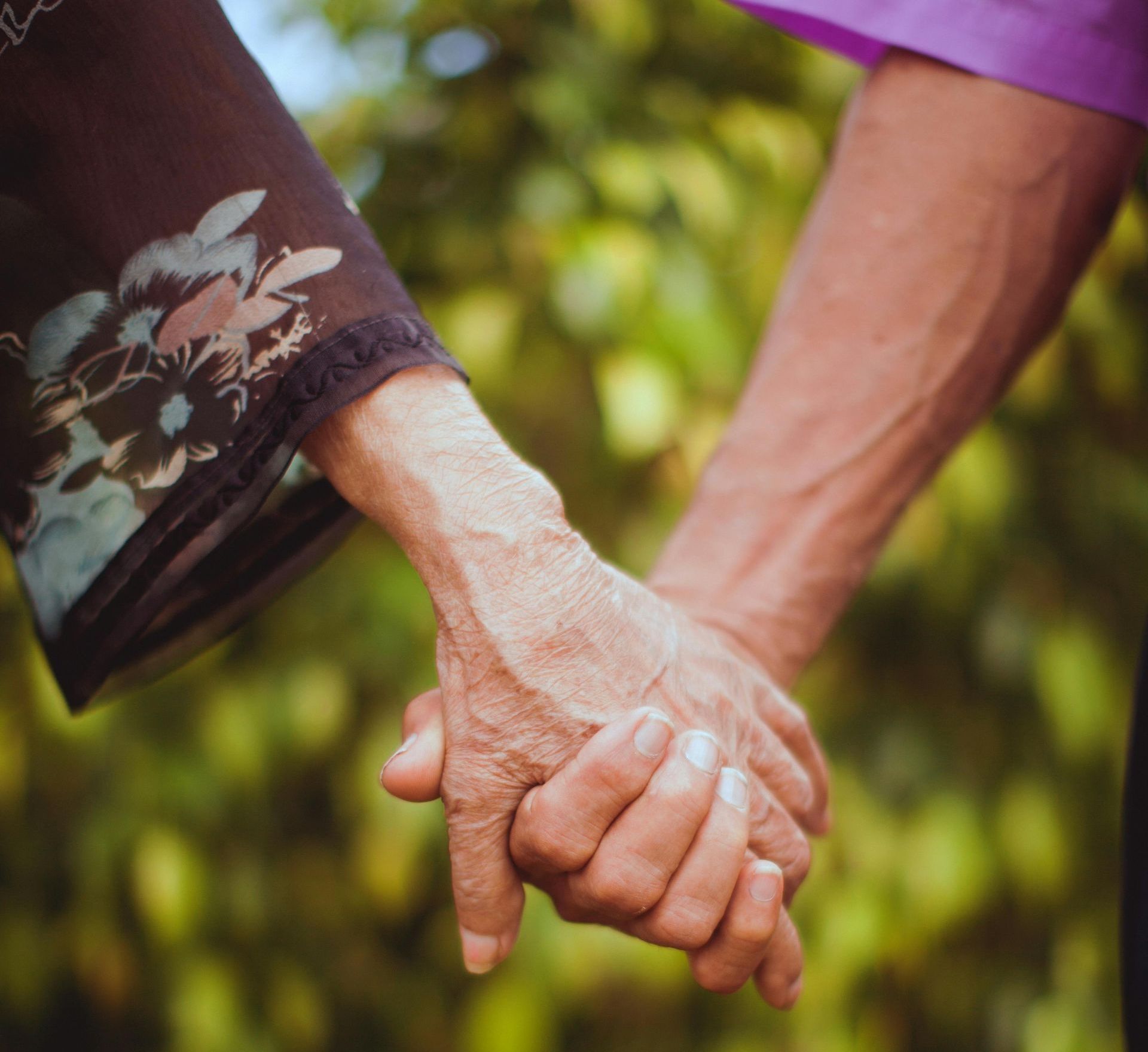 Two old people holding hands