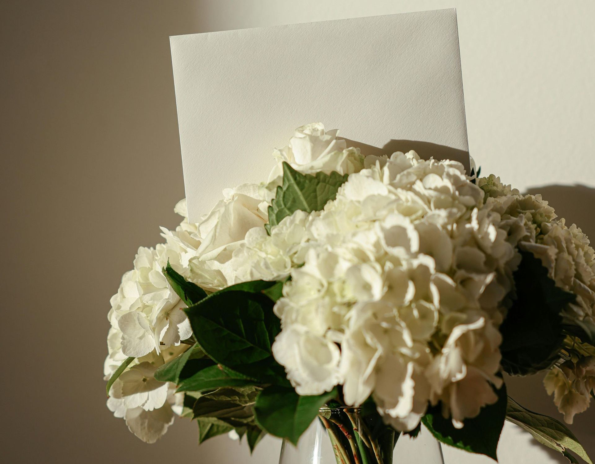 Flowers in a vase with a small envelope
