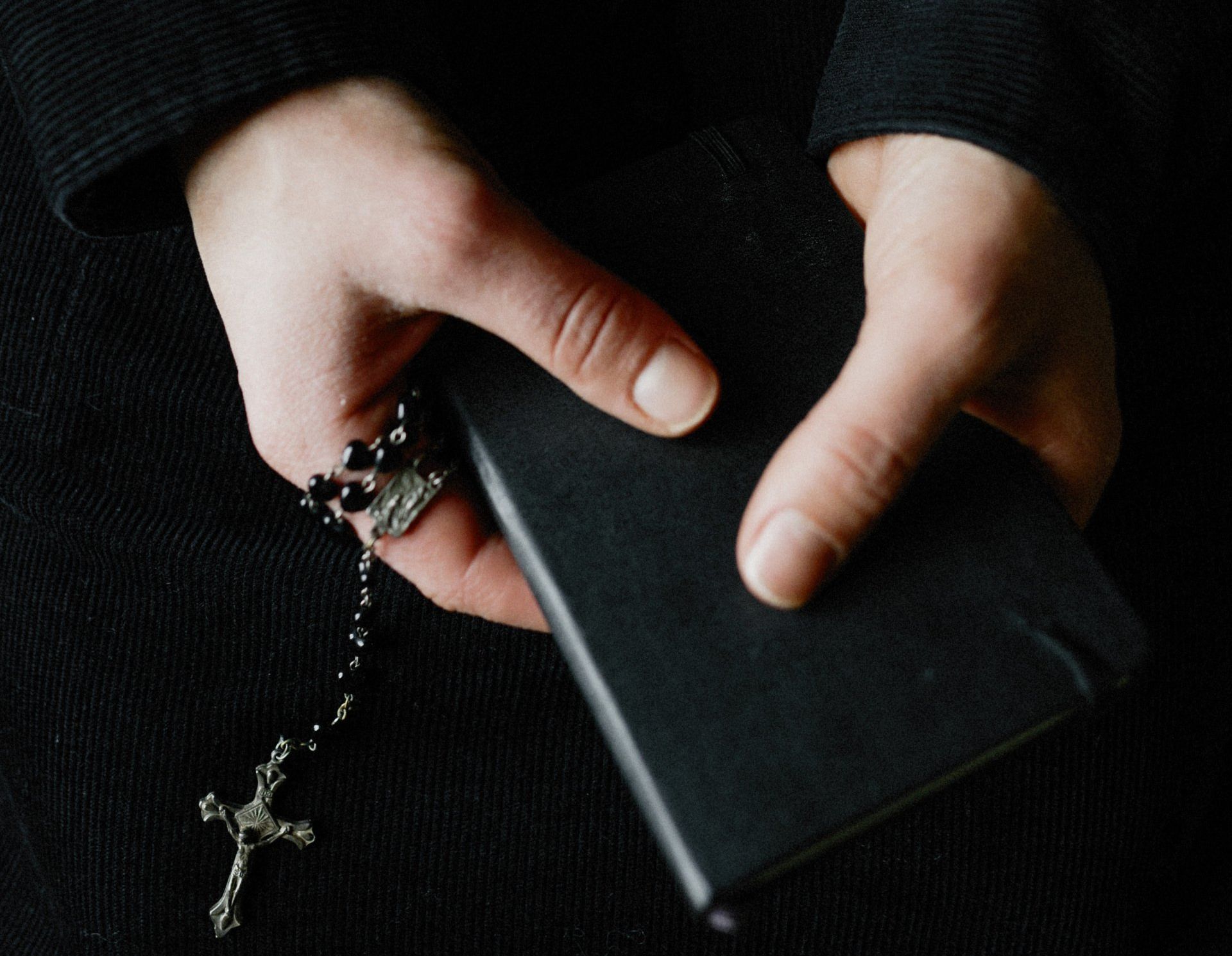 Hands holding a wallet with a crucifix