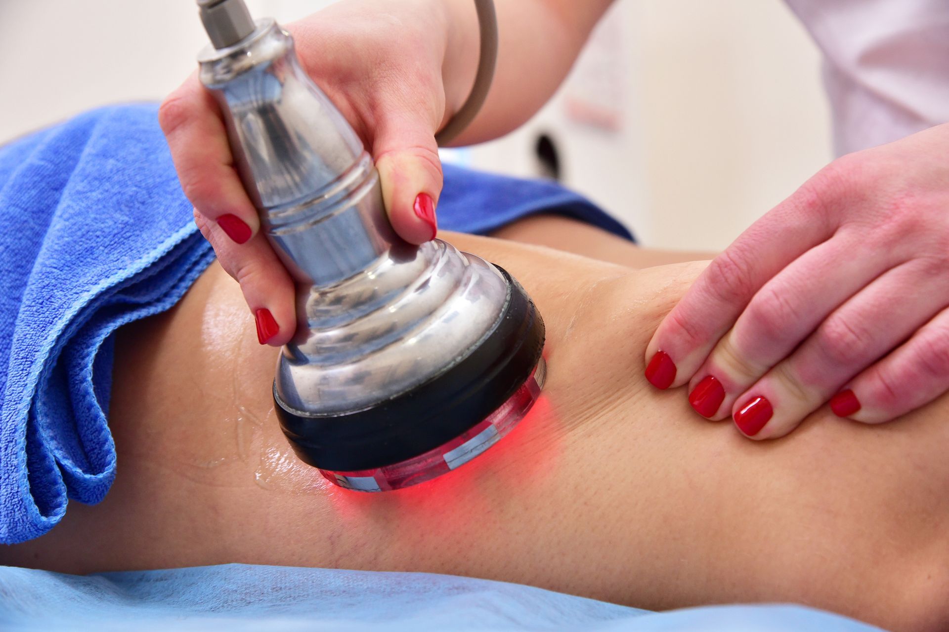 Massage device being applied to a person’s back, with red light therapy and blue towel underneath