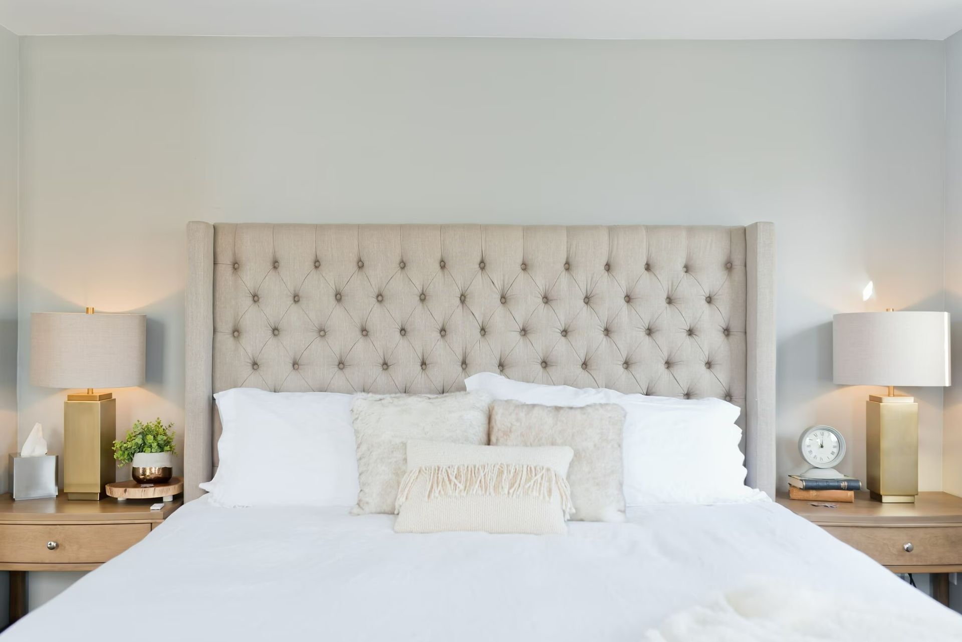 Photo of a bedroom with a bed that has a tall headboard