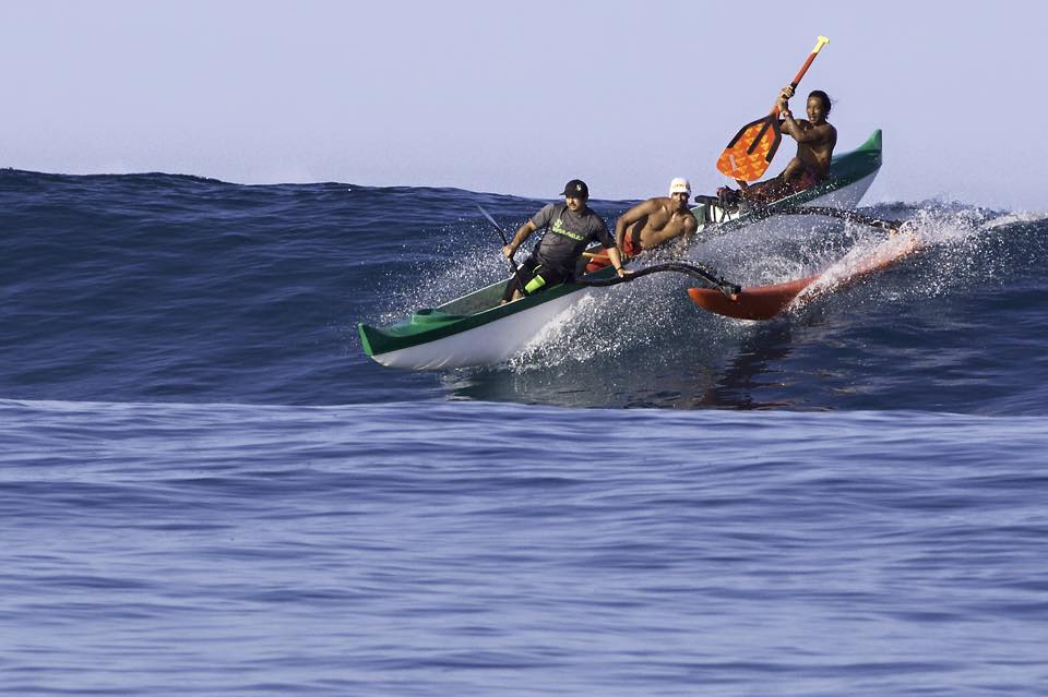 A group of people are riding a wave in a kayak.