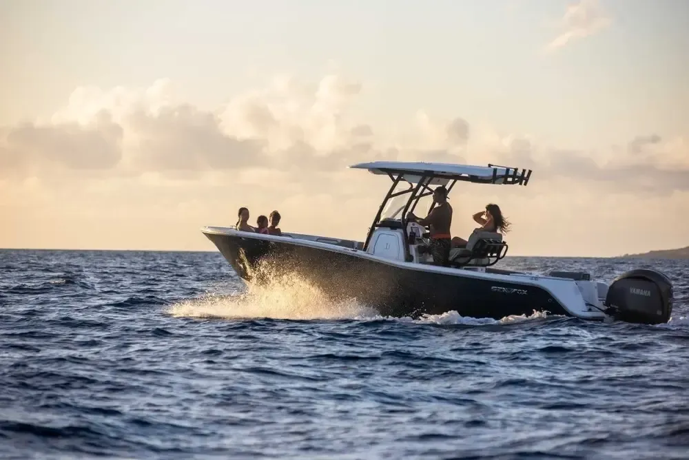 Charter boat with guests onboard at golden hour on a private Kona sunset cruise
