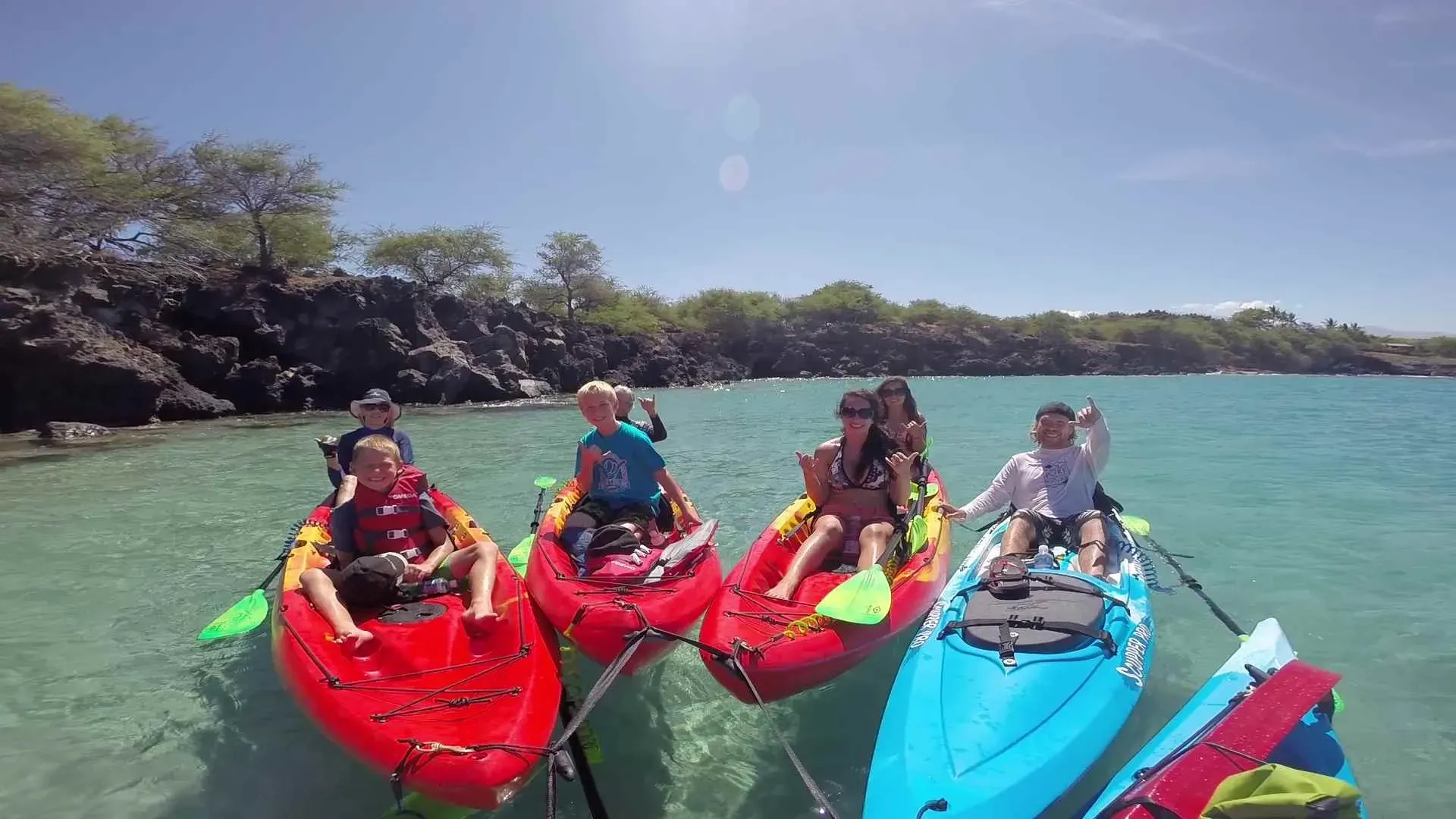 A group of people are sitting in kayaks in the water.