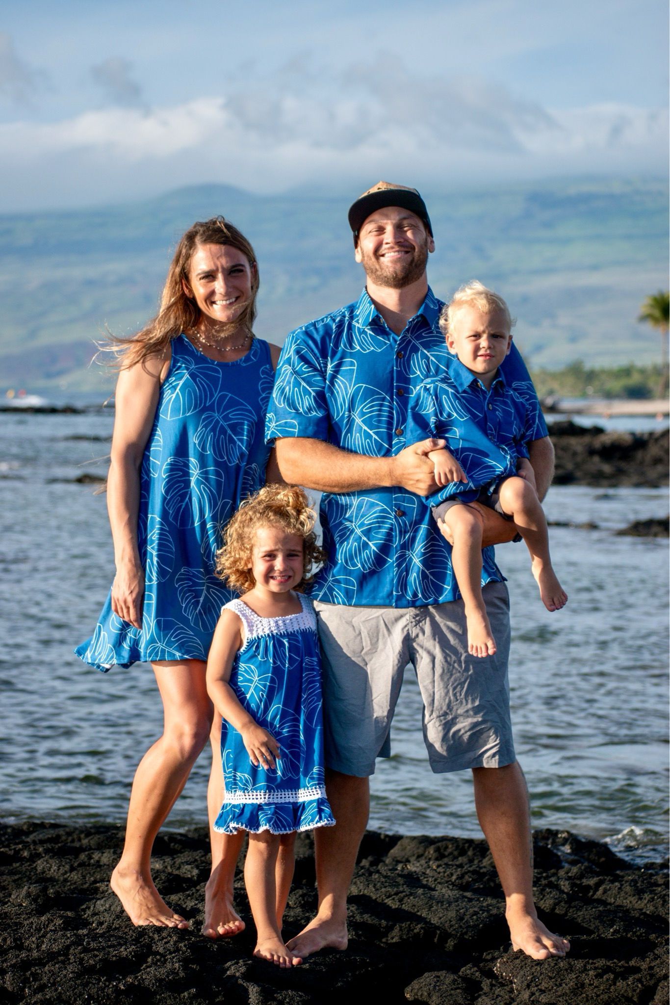 A family is posing for a picture on the beach.