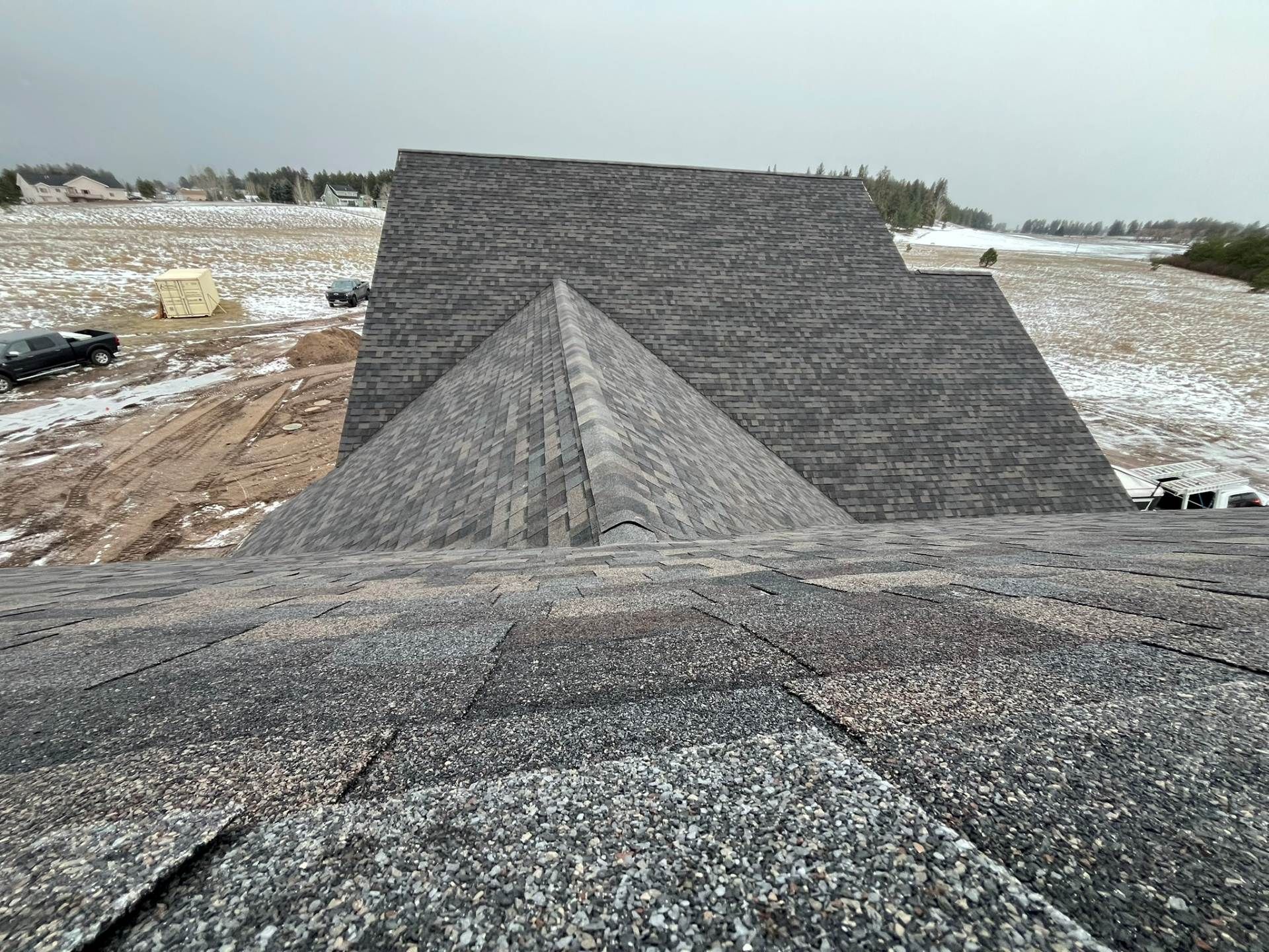 Gray gravel mound on a construction site with a large sloped embankment in the background