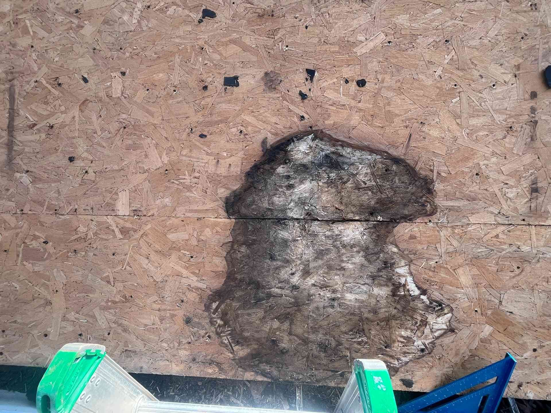 Rusty, stained wall with a dark patch and a few colored plastic pieces at the bottom