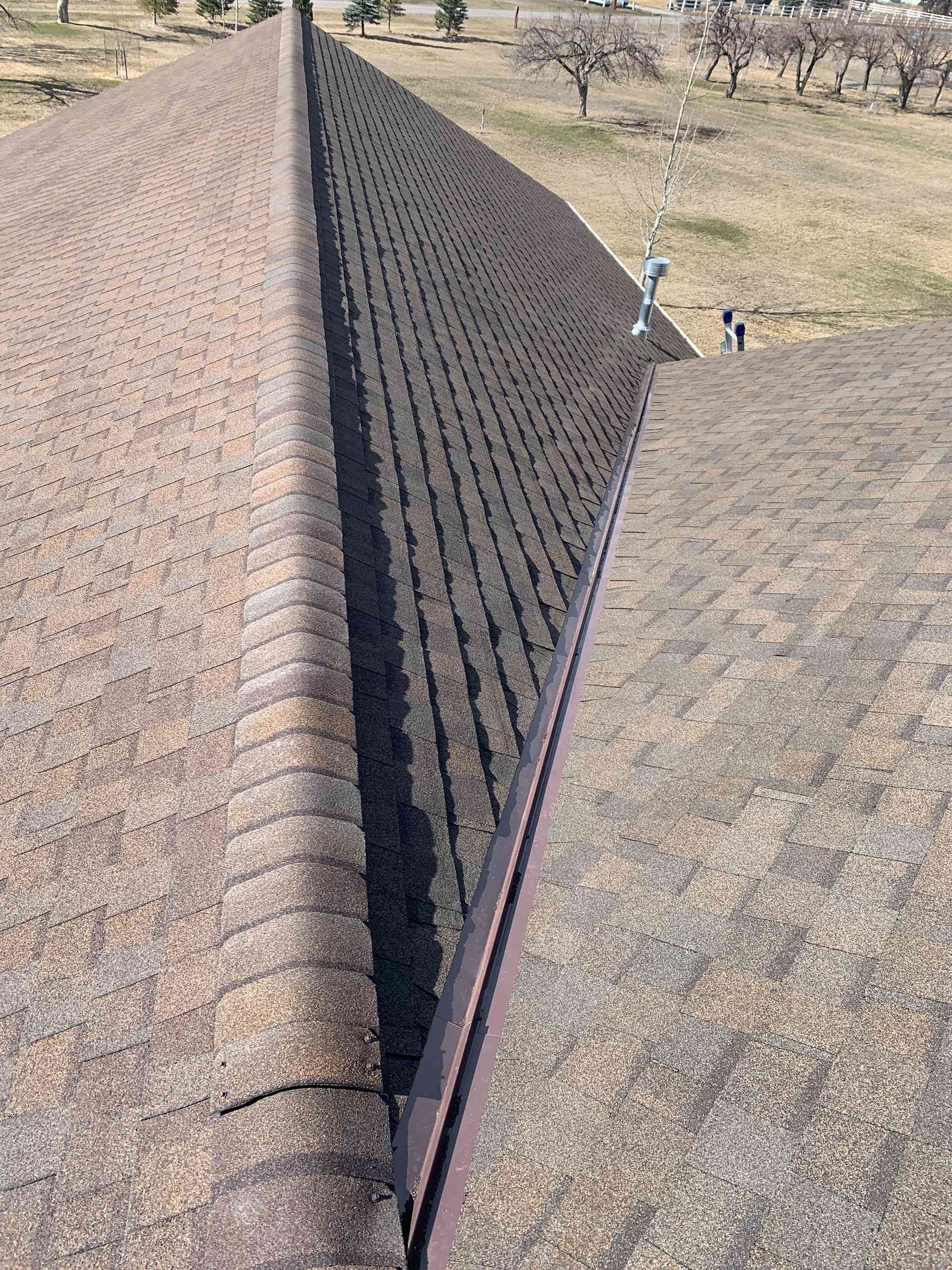 Aerial view of a long irrigation ditch dividing dry fields, with two small people on the right side.