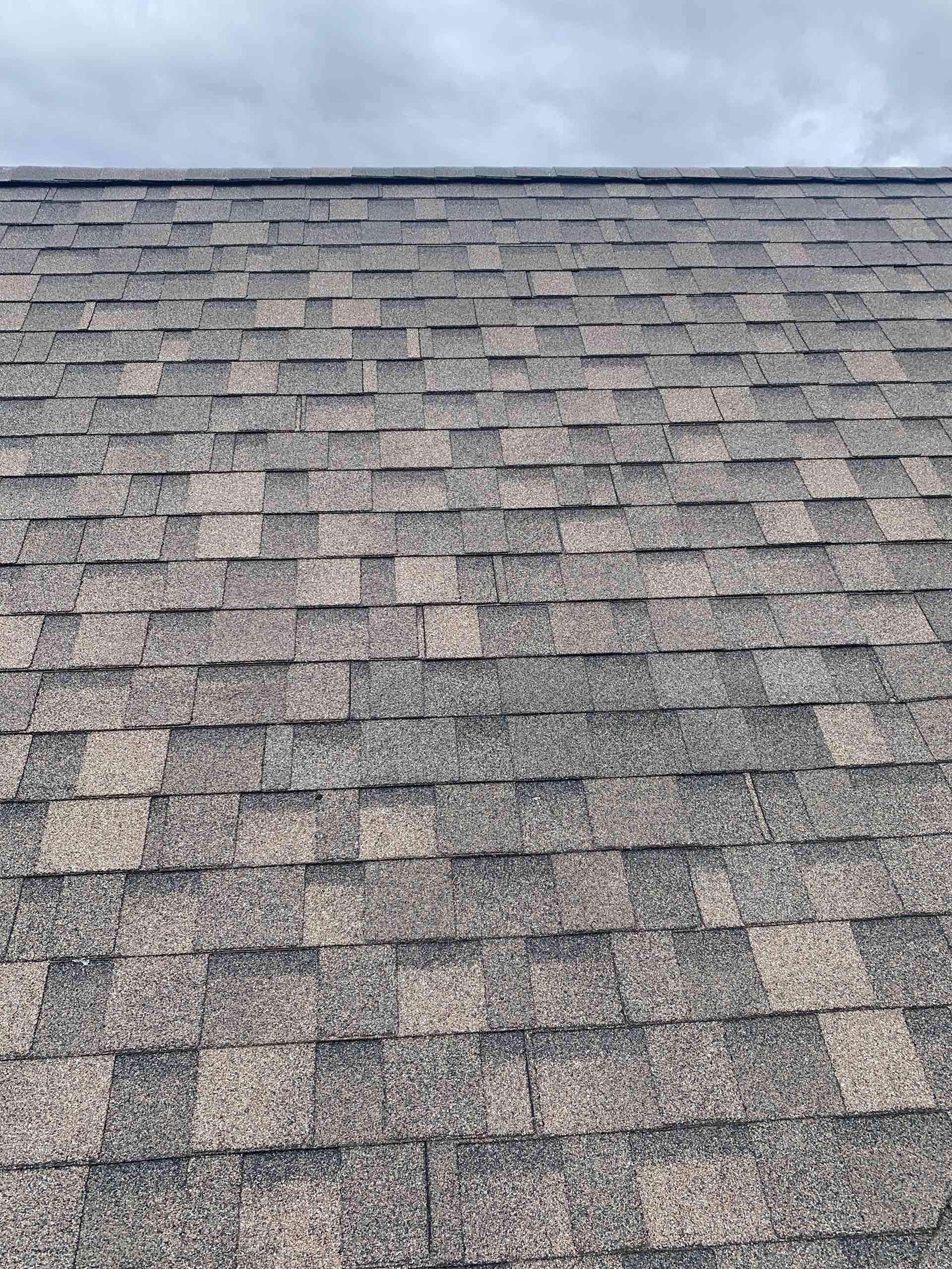 Gray shingled roof seen from above, with a patchy weathered texture.