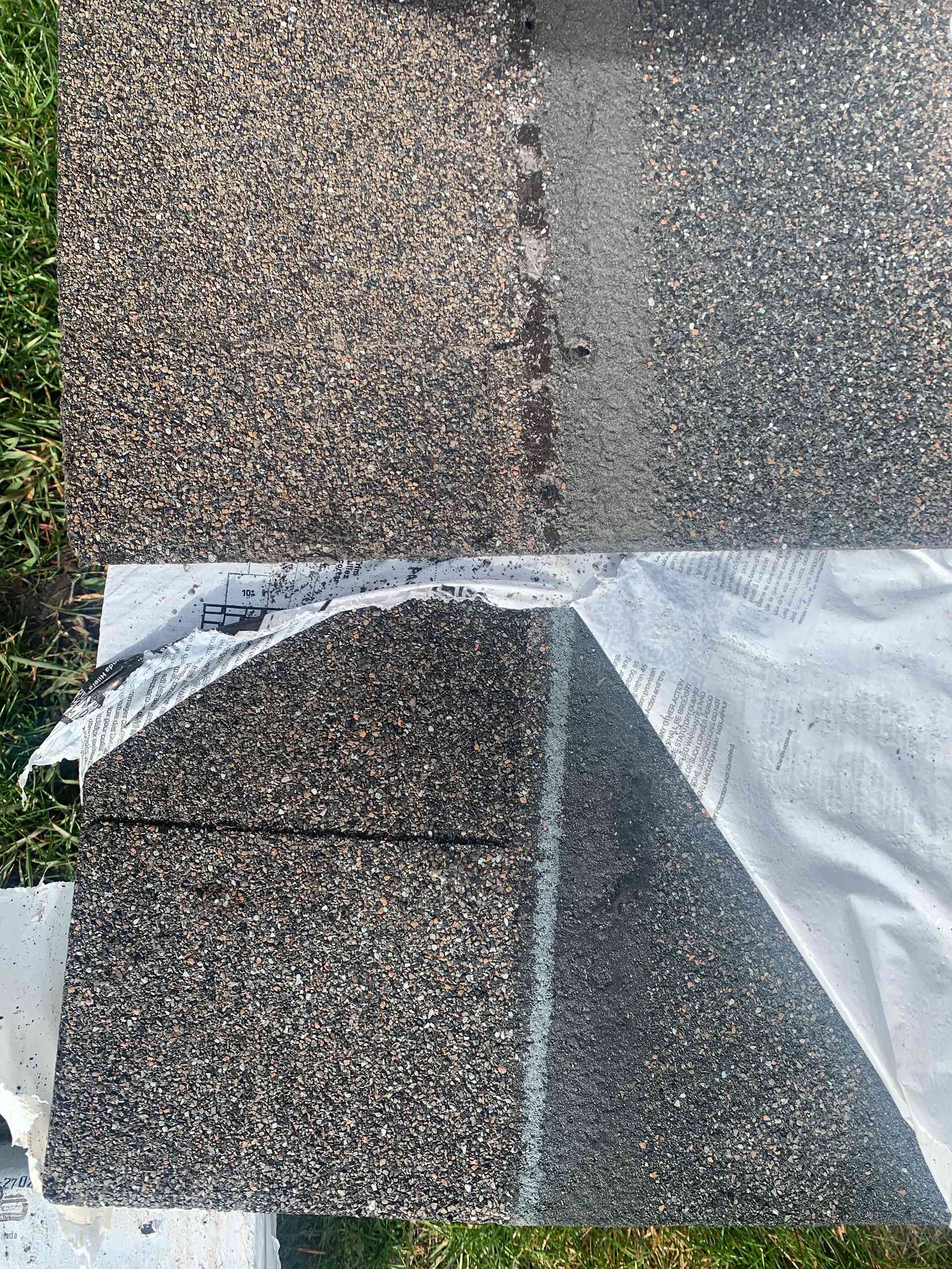 Roof shingles and rolled underlayment laid out in sections on a rooftop under construction