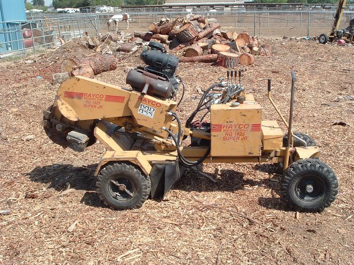 Small homemade trike in a wood yard, loaded with cardboard boxes and containers.