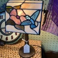 Stained-glass butterfly and flowers lamp glowing on a display table