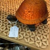Orange turtle with a price tag, resting on a patterned wooden display