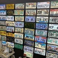 Wall covered with colorful vintage license plates arranged in a grid