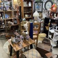 Antique shop filled with vintage furniture, lamps, shelves, and decorative household items