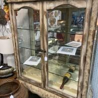 Antique display cabinet with vintage tools and papers on glass shelves
