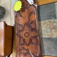 Brown wooden table with floral inlay design, shown next to another wooden piece on a tiled floor.