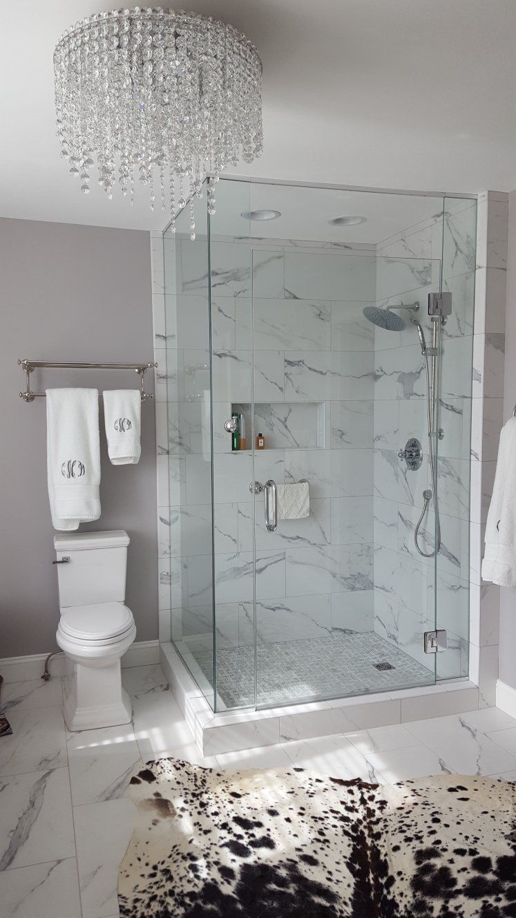Modern bathroom with glass shower, toilet, and crystal chandelier; shattered glass covers the floor Modern bathroom with glass shower, toilet, and crystal chandelier; shattered glass covers the floor