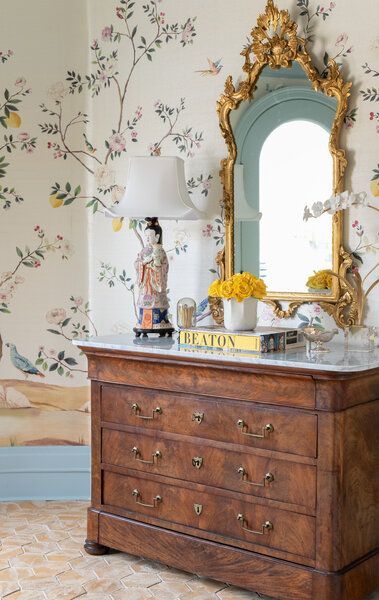A dresser with a mirror and a lamp on top of it
