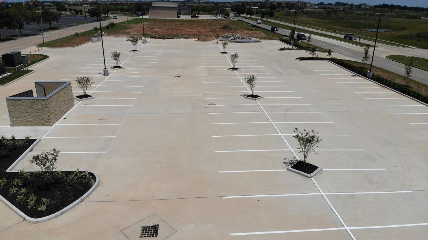 An aerial view of an empty parking lot with trees in the middle