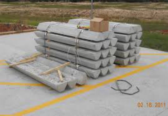 A stack of concrete poles sitting on top of each other on a concrete surface.