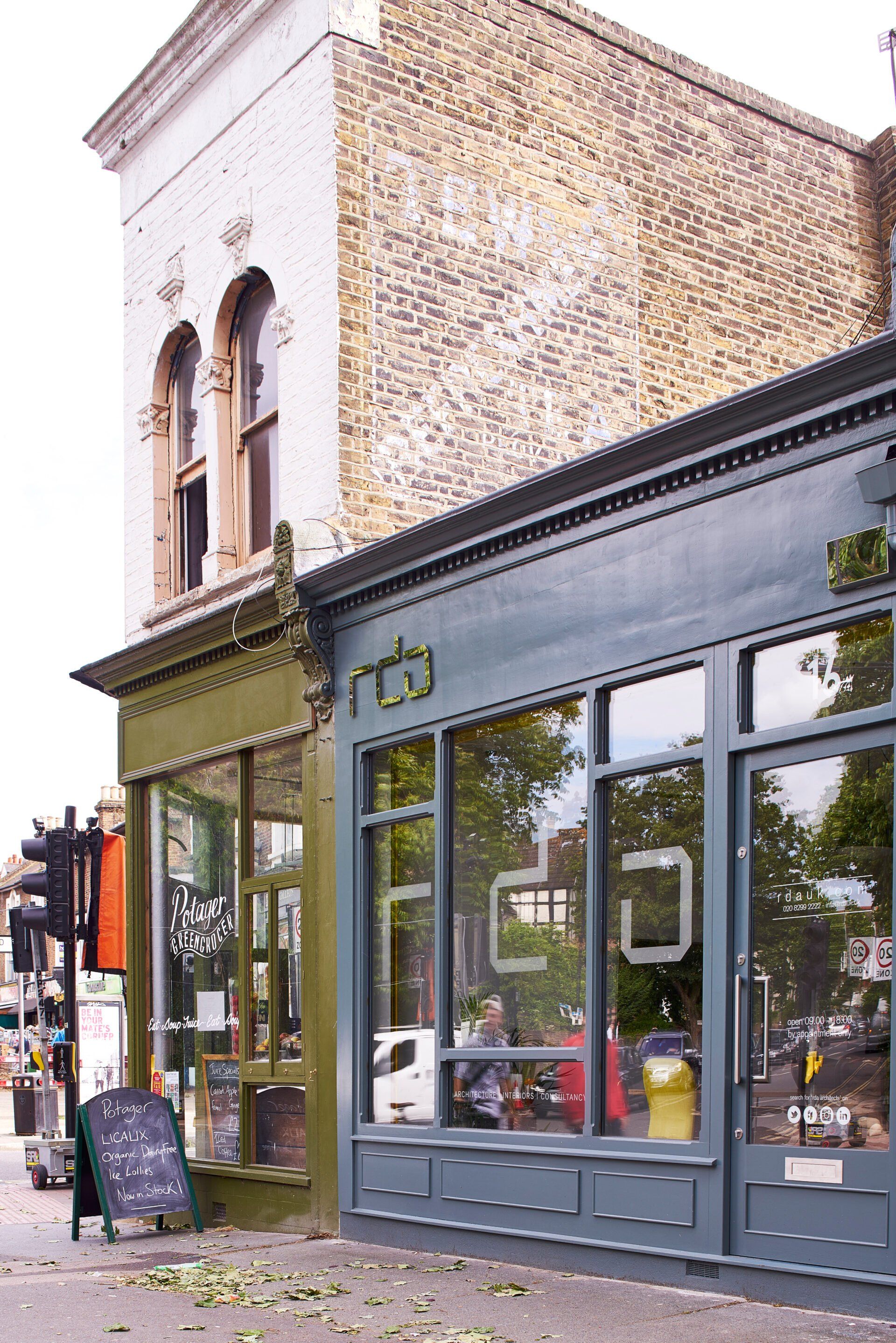 Street-level view of a storefront with large windows beneath a brick upper facade.