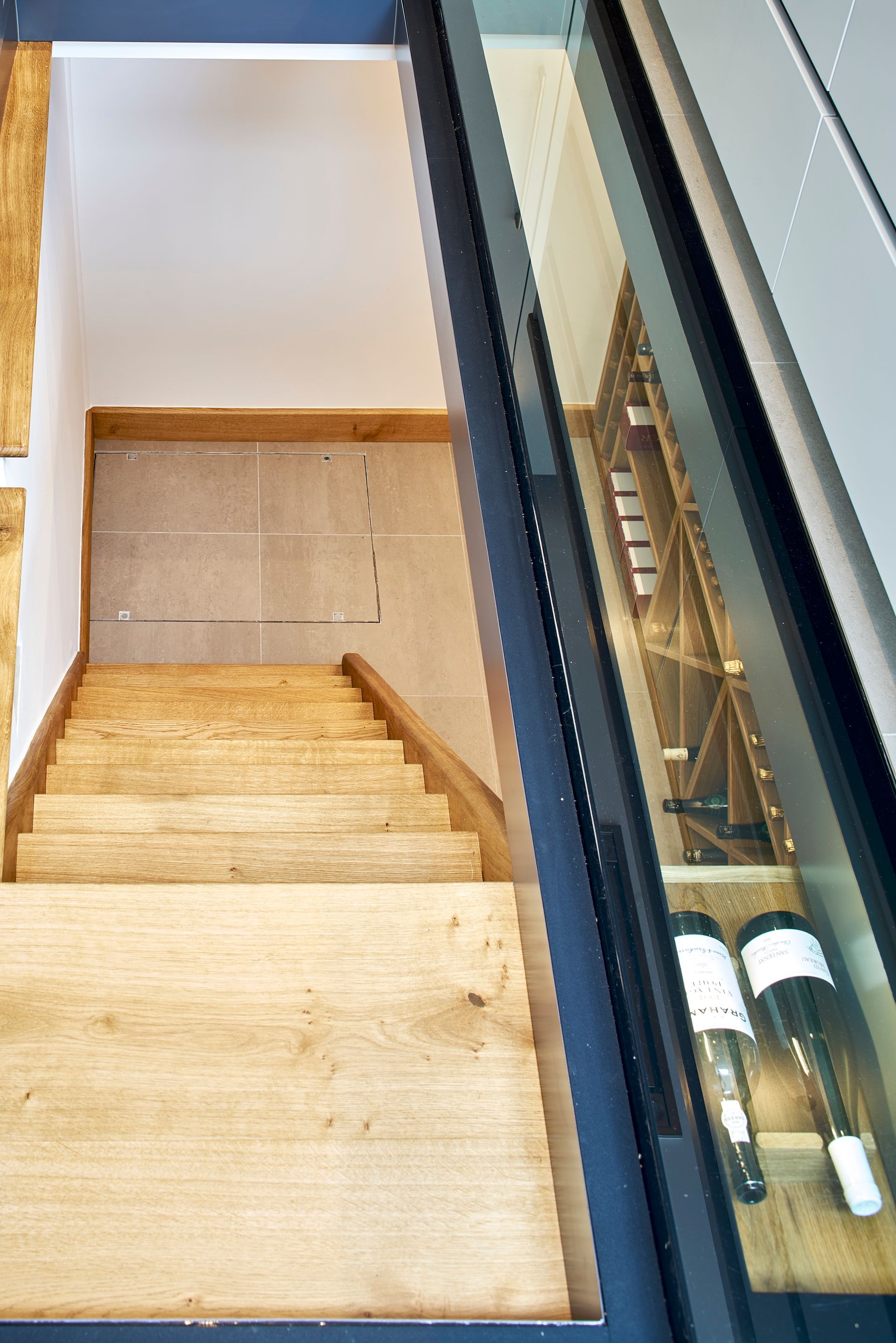 Wooden staircase beside a glass railing in a modern interior.