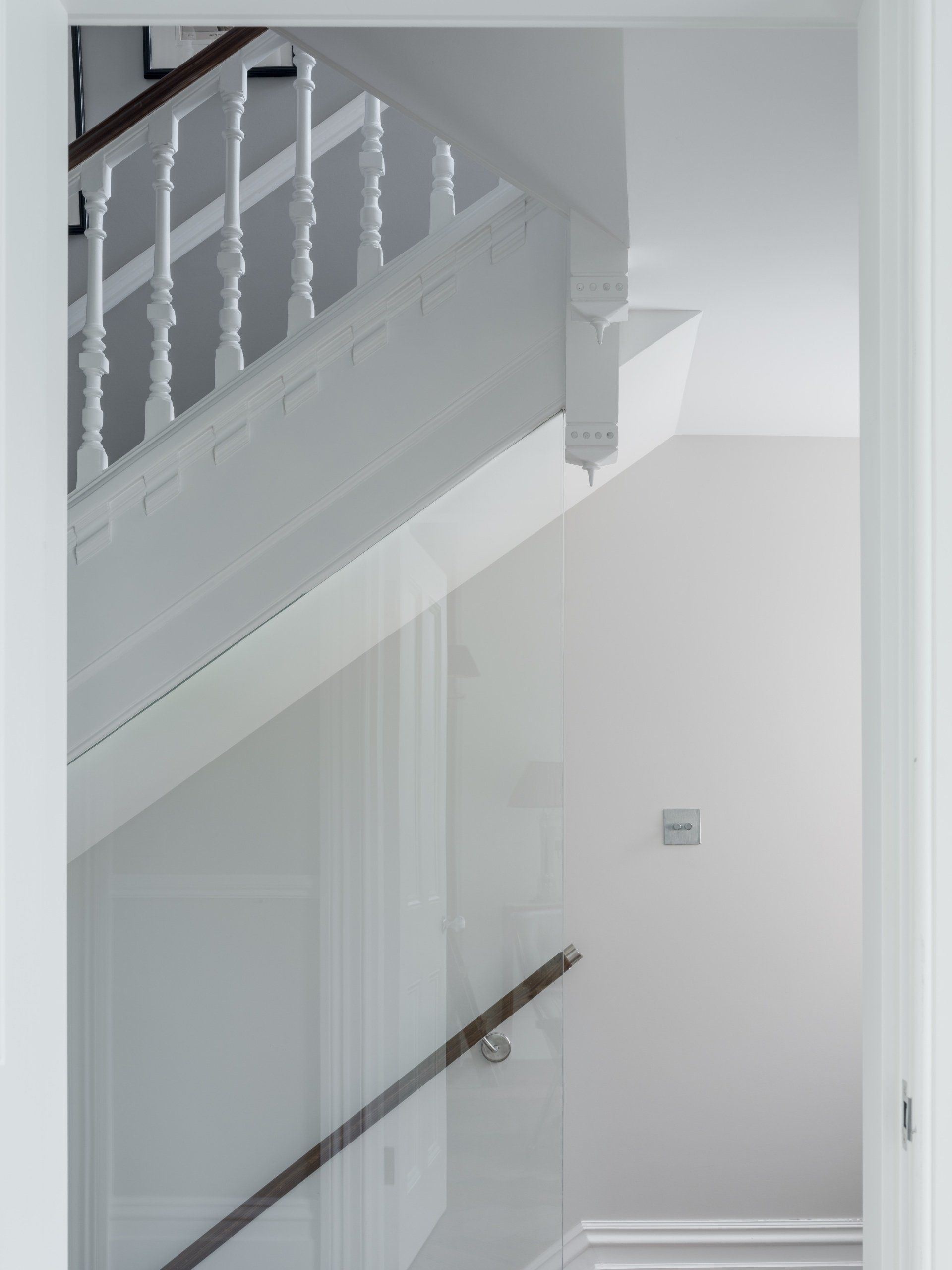 White indoor stairwell with a handrail and white walls