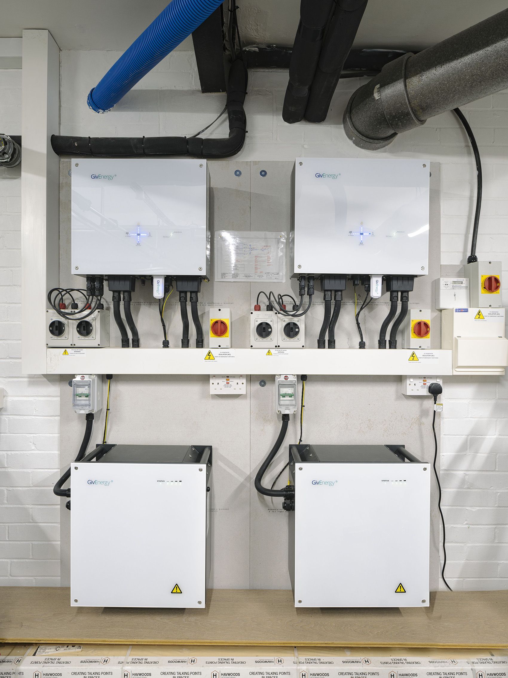 Wall-mounted electrical control boxes and inverters with cables in a utility room