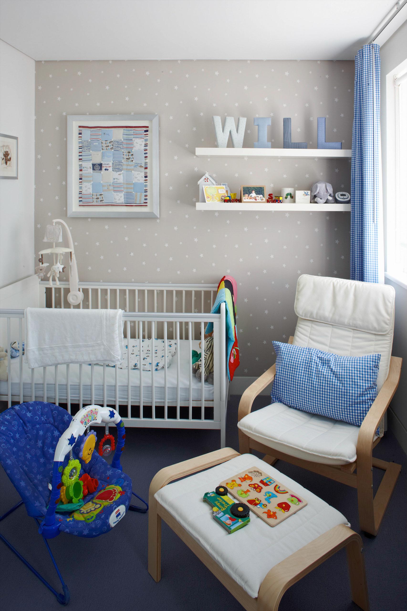 Cozy nursery with white crib, chair, wall shelves, and blue patterned accents