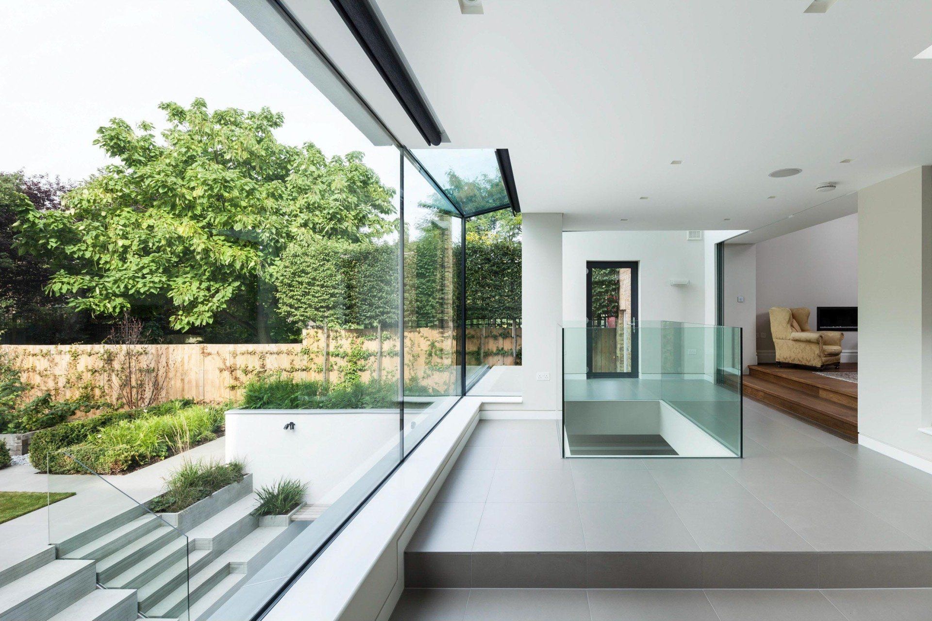 Modern house interior with glass balcony overlooking a green garden