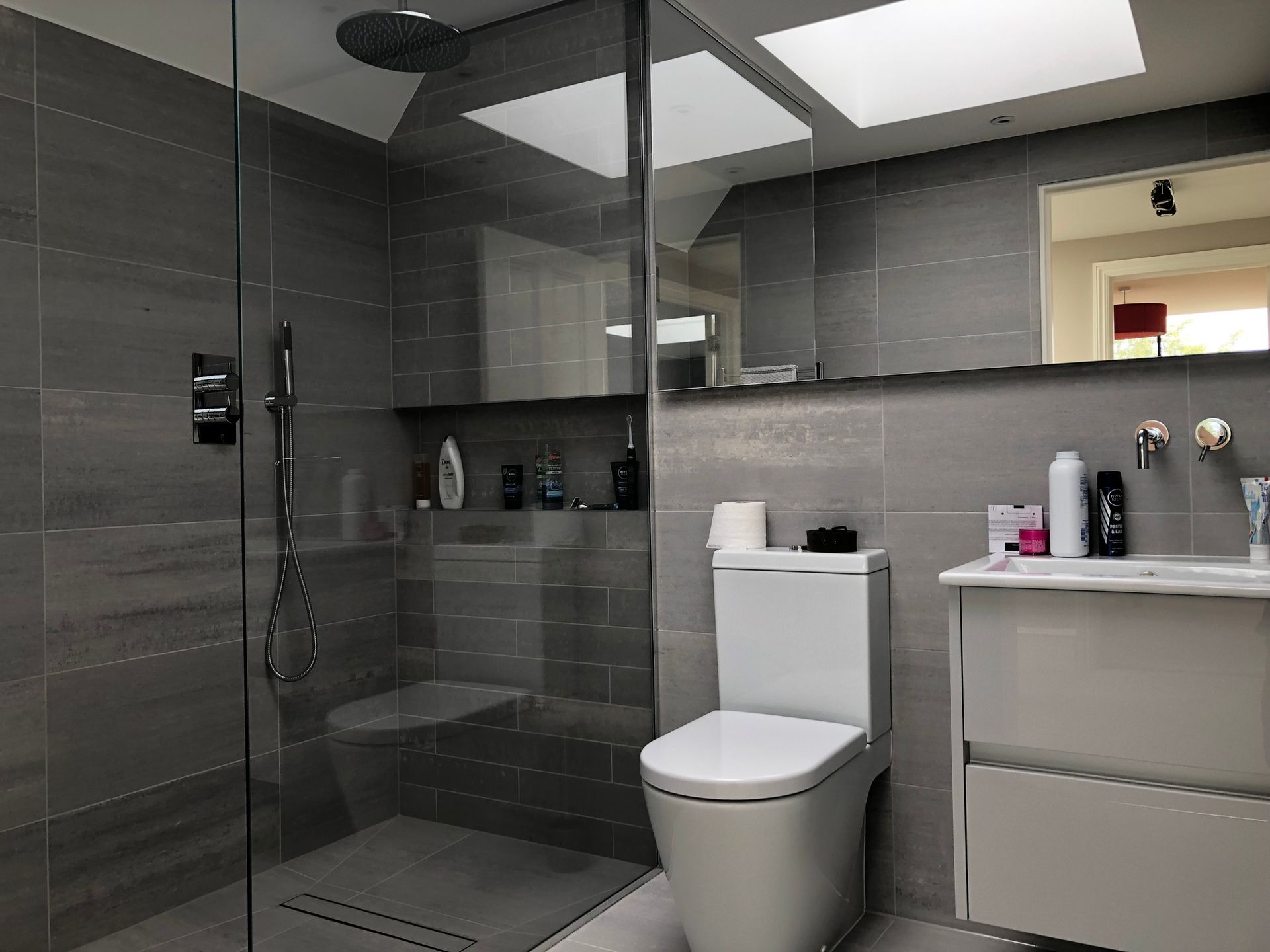 Modern bathroom with glass shower, toilet, and vanity sink