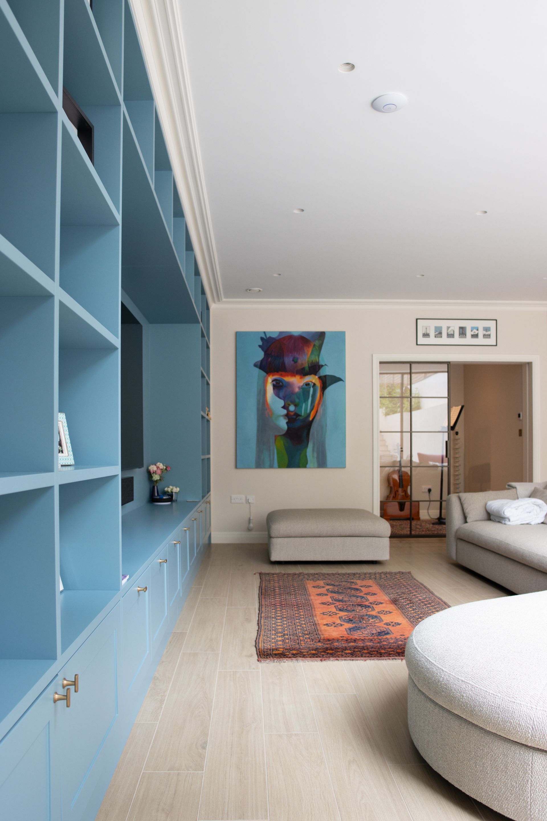 Bright minimalist bedroom with open glass doors leading to a tiled bathroom or hallway at the back