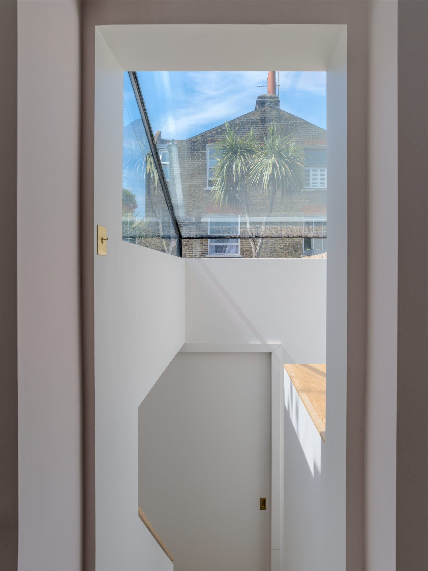 White door with frosted upper glass panel, showing a street and rooftops outside.